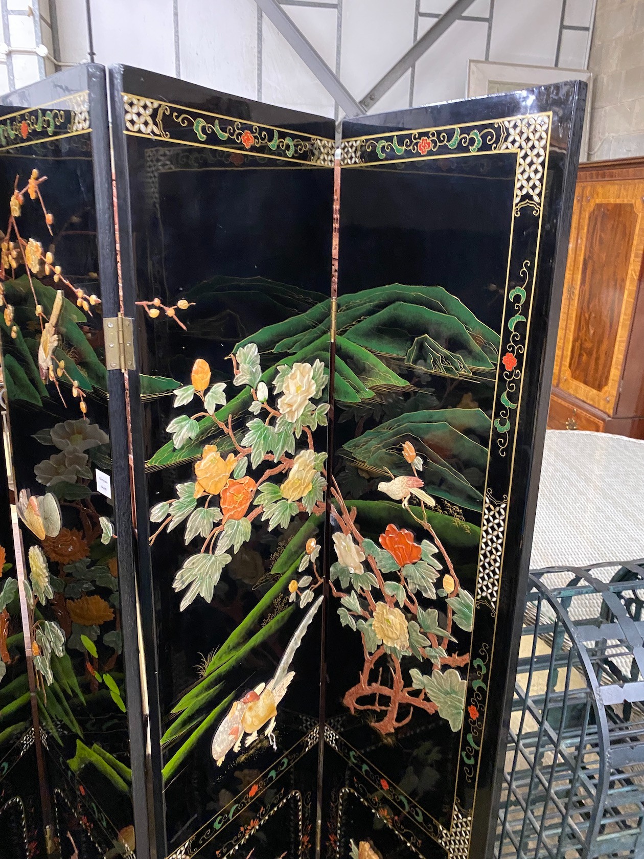 A Chinese black lacquer four fold dressing screen, each panel width 40cm, height 185cm